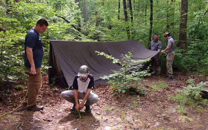 people assemble a shelter on an outward bound expedition for families in north carolina